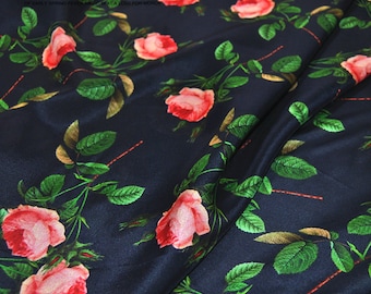 May include: Dark blue fabric with a repeating pattern of pink roses and green leaves. The fabric has a satin finish.