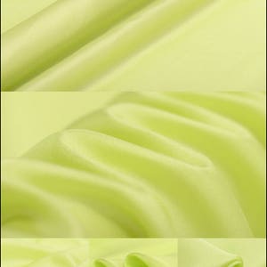 Puede incluir: Un primer plano de una tela verde claro con una textura suave y sedosa. La tela está doblada y drapeada, mostrando su caída y flujo. La tela es un material ligero y aireado que sería perfecto para un vestido de verano o una blusa.