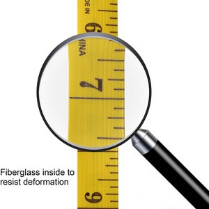 May include: A close-up of a yellow measuring tape with black markings. The tape is labeled "MADE IN CHINA" and shows the numbers 6, 7, and 9. A magnifying glass is positioned over the number 7. The text "Fiberglass inside to resist deformation" is visible below the tape.