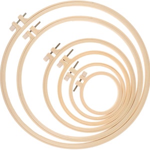 Op de afbeelding: Set van vijf houten borduurringen in verschillende maten. De ringen zijn in elkaar genest, met de grootste ring aan de buitenkant en de kleinste ring aan de binnenkant.