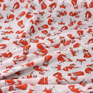 May include: White fabric with a repeating pattern of red foxes. The foxes are all facing the same direction and have black eyes and noses.