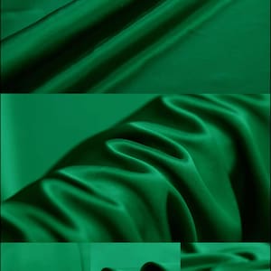 May include: A close-up of a deep green satin fabric. The fabric is smooth and silky, with a slight sheen. The fabric is folded in a way that shows its drape and texture.