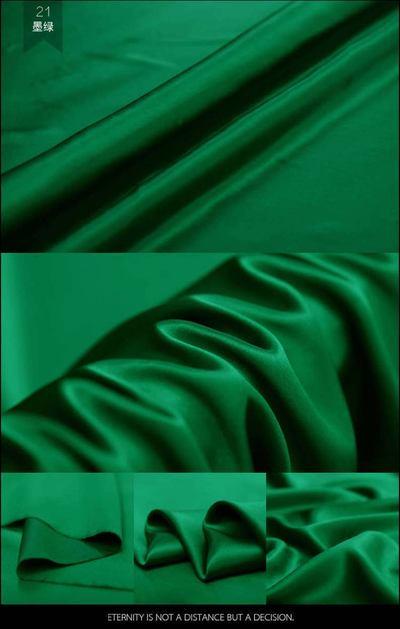 May include: A close-up of a deep green satin fabric. The fabric is smooth and silky, with a slight sheen. The fabric is folded in a way that shows its drape and texture.
