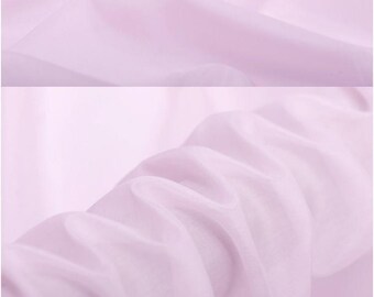 Puede incluir: Un primer plano de una tela transparente de color rosa pálido. La tela es lisa y tiene un drapeado delicado. La tela está doblada en varios lugares, mostrando la textura y la translucidez.