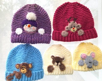 Könnte beinhalten: Fünf gestrickte Mützen mit verschiedenen Tier-Applikationen. Die Mützen sind lila, rot, blau, cremefarben und gelb. Die Tiere sind ein Schneemann, ein Rentier, ein Bär, ein Bär und eine Maus.