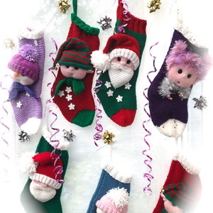 Puede incluir: Siete calcetines de Navidad tejidos con diferentes personajes en la parte delantera. Los calcetines están colgados de una pared blanca con cinta rizada plateada y dorada. Los personajes incluyen un muñeco de nieve, un elfo, Papá Noel, una niña, un pingüino y dos elfos más.