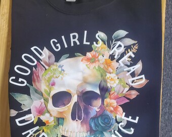 Peut inclure: Sweat-shirt noir avec un motif graphique blanc d'un crâne avec des fleurs et le texte "Good Girls Read Dark Romance".