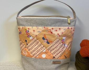 Bolsa com alça superior e zíper, com nécessaire, patchwork e borboletas.