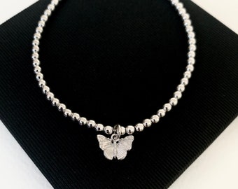Pulsera de plata con mariposas, ensartada a mano en alambre de joyería resistente y con cierre de mosquetón.