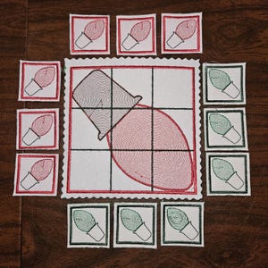 以下が含まれることがあります： クリスマスをテーマにしたキルトのテーブルランナー。中央に大きな赤と黒の電球のデザインがあり、周囲には赤と緑の電球モチーフの小さな正方形のパッチが配置されています。デザインは白い背景に赤い縁取りがされています。