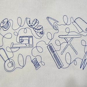 Puede incluir: Un diseño bordado en azul de herramientas de costura sobre un fondo de tela blanco. El diseño incluye una máquina de coser, una bobina de hilo, una cinta métrica, un alfiler, un par de tijeras, una plancha y una regla.