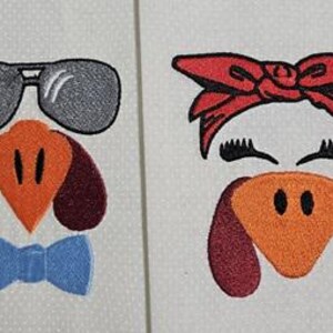 May include: Embroidered turkey face designs. One features sunglasses and a blue bow tie, the other a red bow and eyelashes. Both have orange beaks and burgundy snoods, set against a white background.