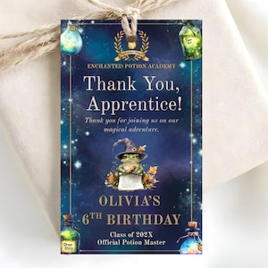 May include: A rectangular gift tag with a dark blue starry background featuring a frog wearing a wizard hat, holding a scroll. Text reads: Thank You, Apprentice! Olivia's 6th Birthday, Class of 202X, Official Potion Master. Includes potion bottle illustrations.