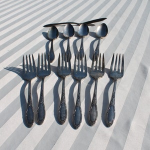 May include: A set of ten silver-plated forks and spoons. The forks and spoons are arranged in two rows, with the forks in the front and the spoons in the back. The forks and spoons are all the same design, with a simple, elegant shape.