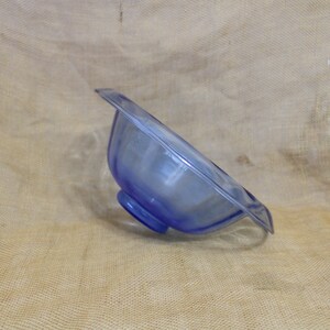 May include: A blue glass bowl with a scalloped rim and a pedestal base.