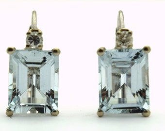May include: A pair of silver earrings with light blue aquamarine gemstones and small clear diamond accents.