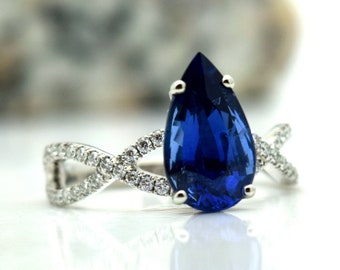 May include: A pear-shaped sapphire engagement ring with a twisted band set with small diamonds.