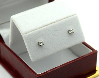 May include: A pair of diamond earrings in a red velvet jewelry box with a gold trim.