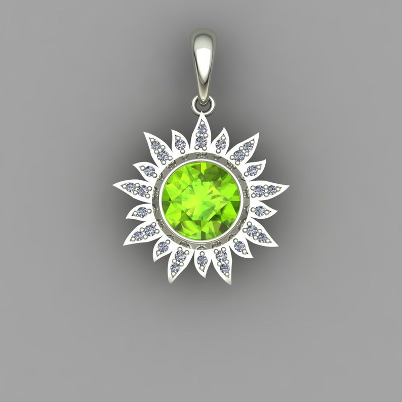 May include: A silver pendant featuring a green gemstone surrounded by a halo of smaller white gemstones. The pendant is shaped like a sun with rays extending from the center.
