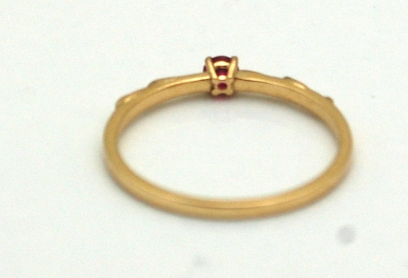 Peut inclure: Une bague en or avec une seule pierre pr&eacute;cieuse rouge sertie au centre.