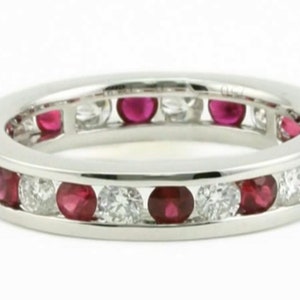 May include: A platinum eternity band with a row of alternating ruby and diamond stones.