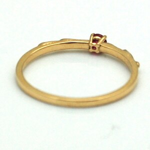 Peut inclure: Une bague en or avec une seule pierre pr&eacute;cieuse rouge sertie au centre.
