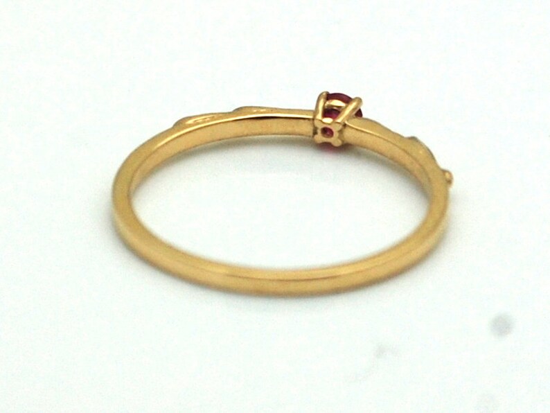 Peut inclure: Une bague en or avec une seule pierre pr&eacute;cieuse rouge sertie au centre.