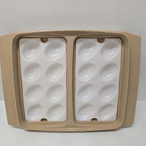 May include: A rectangular beige plastic serving tray featuring two removable white inserts, each containing eight oval-shaped indentations designed for holding deviled eggs. The tray has integrated handles on both sides and a textured finish.