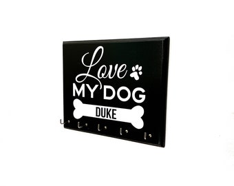 May include: Black wooden key holder with the text "Love My Dog" and a bone with the name "Duke" on it. There are six hooks on the bottom.