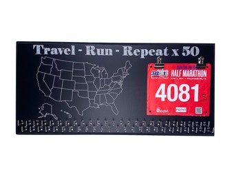 May include: Black wooden board with a map of the United States, a running race bib with the number 4081, and the text "Travel - Run - Repeat x 50".