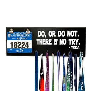 May include: Black wooden medal display board with the quote "DO, OR DO NOT. THERE IS NO TRY. - YODA" in white text. Includes a race bib and several colorful race medals hanging below.