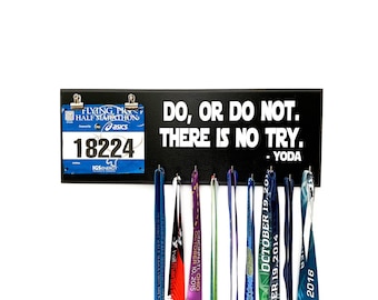 May include: Black wooden medal display board with the quote "DO, OR DO NOT. THERE IS NO TRY. - YODA" in white text. Includes a race bib and several colorful race medals hanging below.