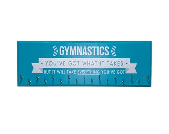 May include: A teal blue wooden medal hanger with silver hooks and the text ">> GYMNASTICS <<  • YOU'VE GOT WHAT IT TAKES. BUT IT WILL TAKE EVERYTHING YOU'VE GOT"
