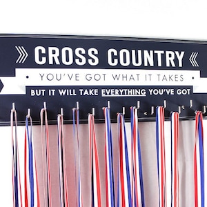 May include: A navy blue wooden medal display with the words "CROSS COUNTRY" and motivational text in white. The display has hooks holding red, white, and blue ribbons, perfect for showcasing achievements.