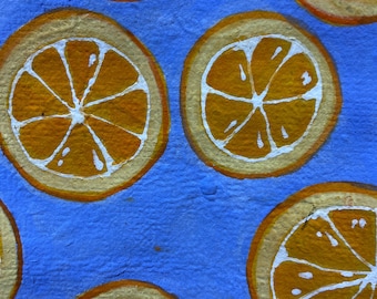 Watercolor painting of orange on blue background on handmade paper