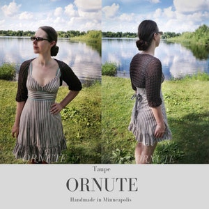 May include: A woman wearing a taupe-colored, open-front, short-sleeved shrug over a striped dress. The dress has a ruffled hem. The image includes the text "ORNUTE" and "Handmade in Minneapolis". The background shows a lake and green grass.