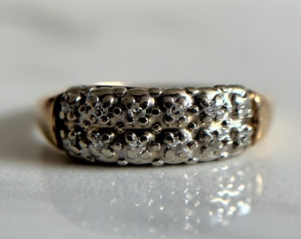 May include: A two-toned gold and silver ring with a band of small diamonds.