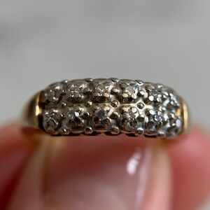 May include: A gold band ring with a double row of small, clear diamonds set in a pave setting.