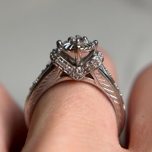 May include: A silver engagement ring with a diamond center stone and smaller diamonds set in the band.