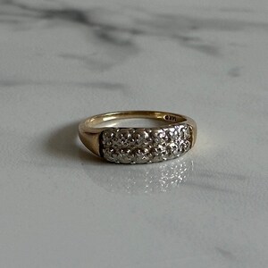 May include: A gold band ring with a double row of small diamonds.