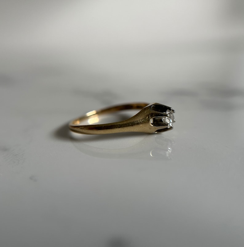 May include: A gold ring with a single diamond set in a prong setting.