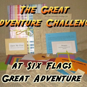 May include: A collection of colorful cards, envelopes, and papers with the text "THE GREAT ADVENTURE CHALLENGE" and "AT SIX FLAGS GREAT ADVENTURE". Includes a bundle tied with a green ribbon and the text "Open Me First".