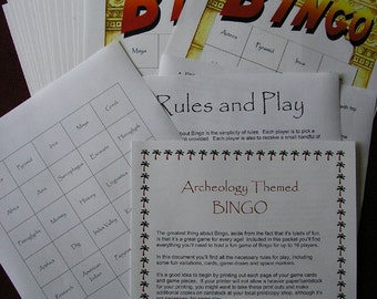 Op de afbeelding: Een stapel bedrukte Bingo-spelvellen met een archeologiethema. De vellen bevatten het woord "BINGO" in grote letters, spelkaarten, regels en ruimtemarkeringen. De spelkaarten bevatten woorden als "Maya" en "Pyramide".