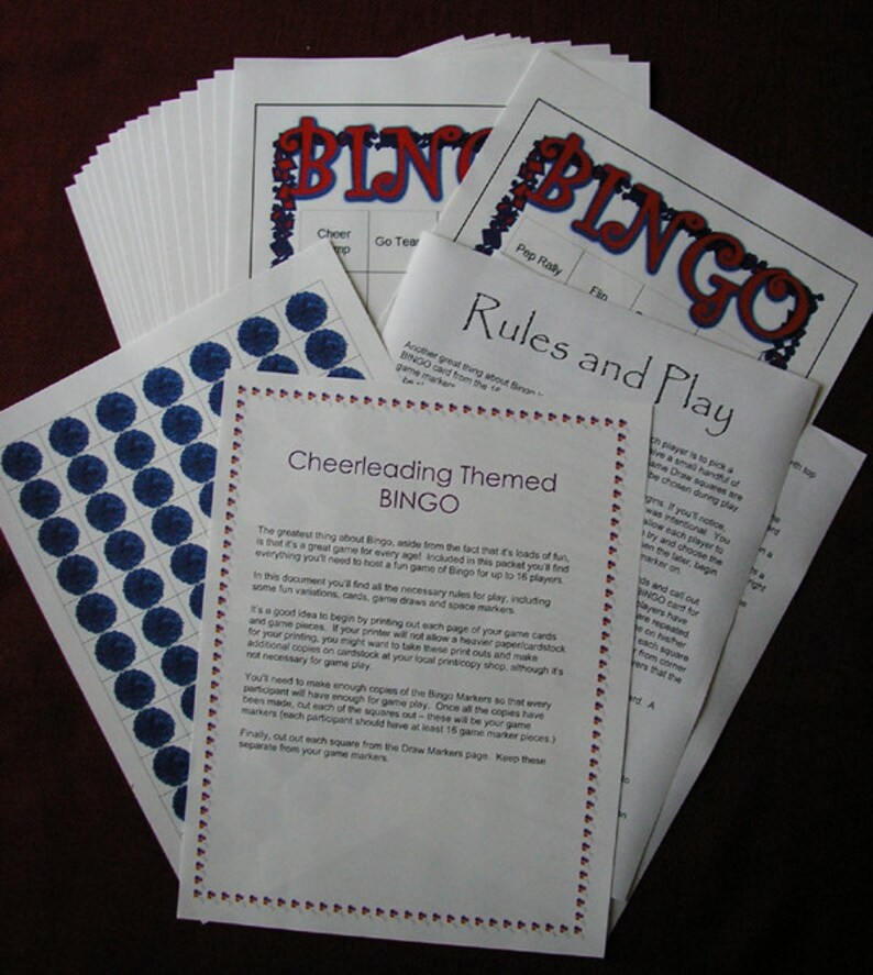 May include: A collection of printed Bingo game materials, including sheets with the word "BINGO" in red and blue, rules, and marker sheets with blue circles. The theme is "Cheerleading".