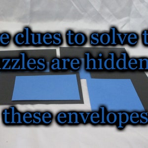 May include: Image shows black and blue rectangular envelopes. Text in blue reads: "The clues to solve the puzzles are hidden in these envelopes."
