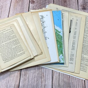 Pu&ograve; includere: Una pila di carta ephemera vintage, tra cui una pagina con testo da un libro intitolato "And Now They Were Seven", una mappa e una pagina di note musicali.