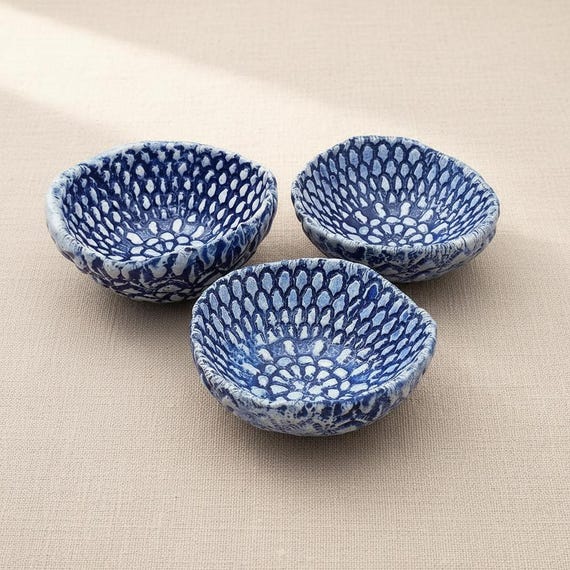 Handbuilt ceramic bowls with real lace pressed into the clay — the texture is genuinely tactile and the set-of-three format makes it gift-ready out of the box.