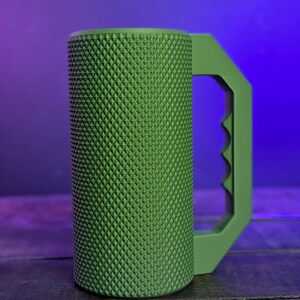 Peut inclure: Un mug cylindrique vert dot&eacute; d'une surface ext&eacute;rieure textur&eacute;e &agrave; motif de losanges. Le mug comprend une anse angulaire robuste avec une s&eacute;rie de trois indentations en forme de doigts sur la zone de pr&eacute;hension int&eacute;rieure.