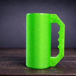 Peut inclure: Une tasse cylindrique vert n&eacute;on vif pr&eacute;sentant une surface ext&eacute;rieure textur&eacute;e &agrave; motif de losanges et une poign&eacute;e g&eacute;om&eacute;trique angulaire avec une s&eacute;rie de petites indentations le long de la zone de pr&eacute;hension pour une prise s&ucirc;re.