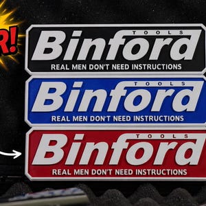 May include: Three Binford Tools logo stickers in black, blue, and red, stacked on top of each other. The stickers have the text "REAL MEN DON'T NEED INSTRUCTIONS". The words "NEW COLOR!" and "NEW RED!" are also visible.